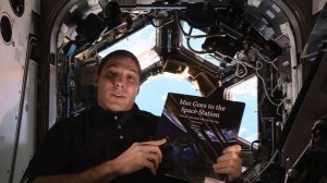 NASA astronaut Mike Hopkins holds the book "Max Goes to the Space Station" inside the real-life space station's Cupola observation deck. The book, written by author Jeffrey Bennett, is part of Story Time From Space.